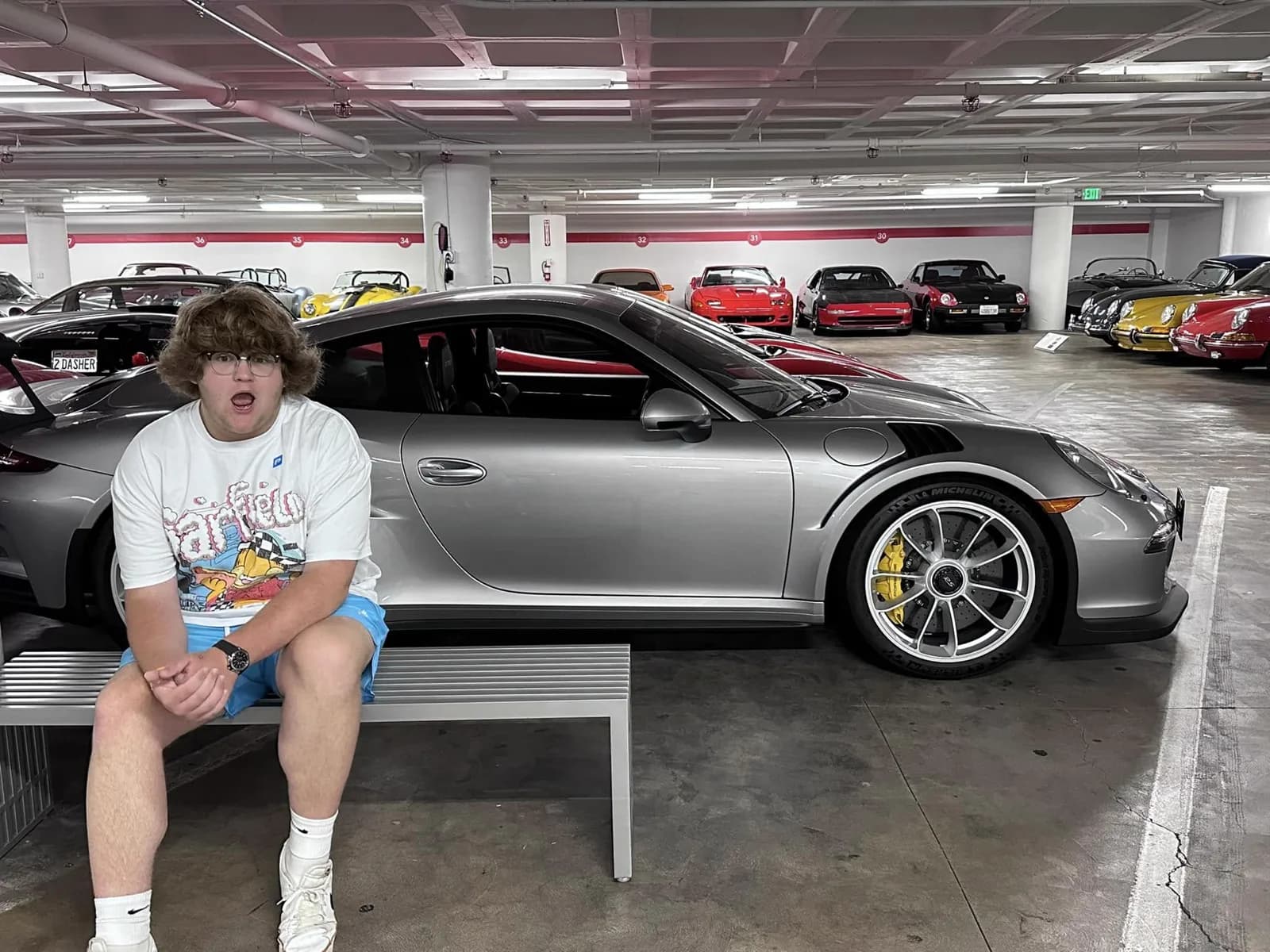 Sam Evans beside a Porsche 911 GT3 RS at the Petersen Automotive Museum vault