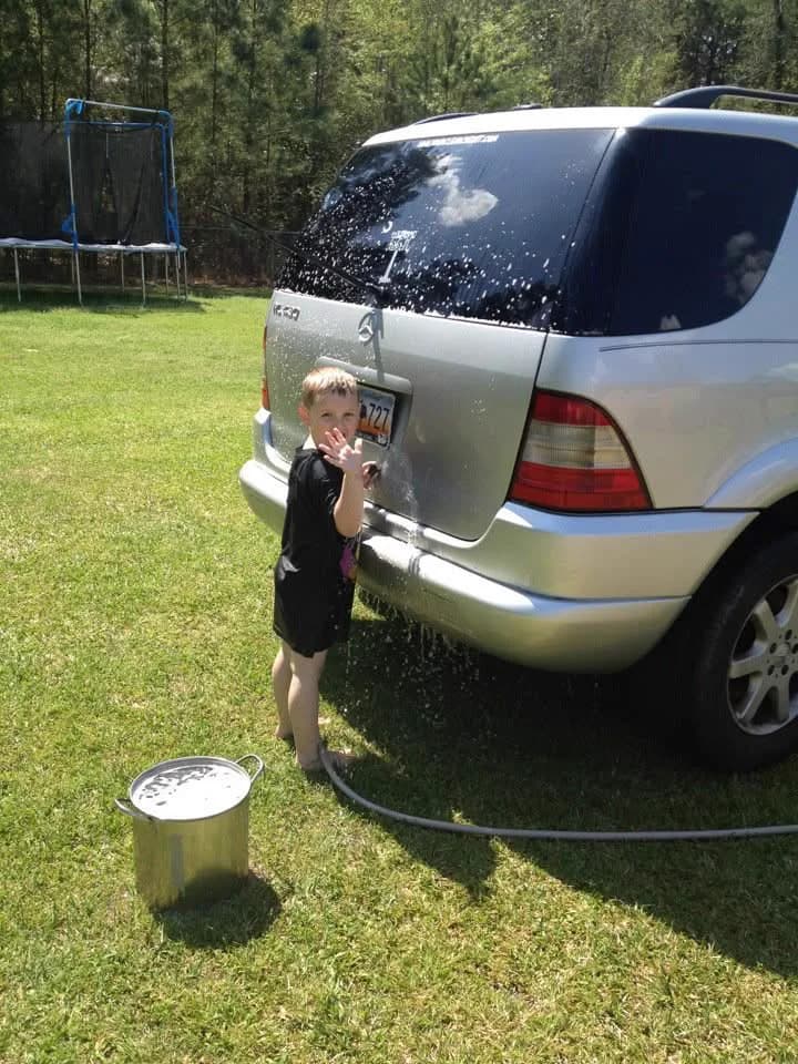 A young Sam Evans washing the family SUV in the backyard